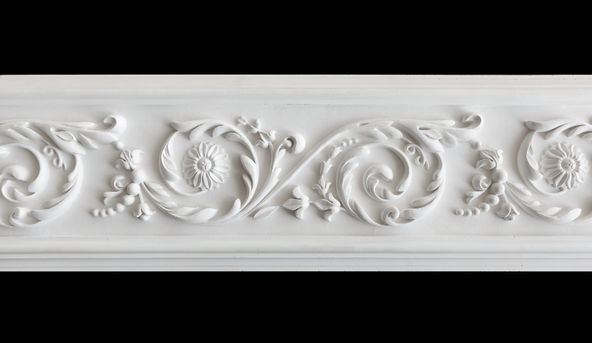 A fragment of a white plaster ceiling molding with an ornament.